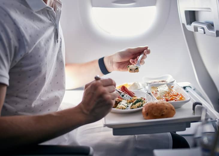 A passenger eating an airline meal during a short-haul flight.