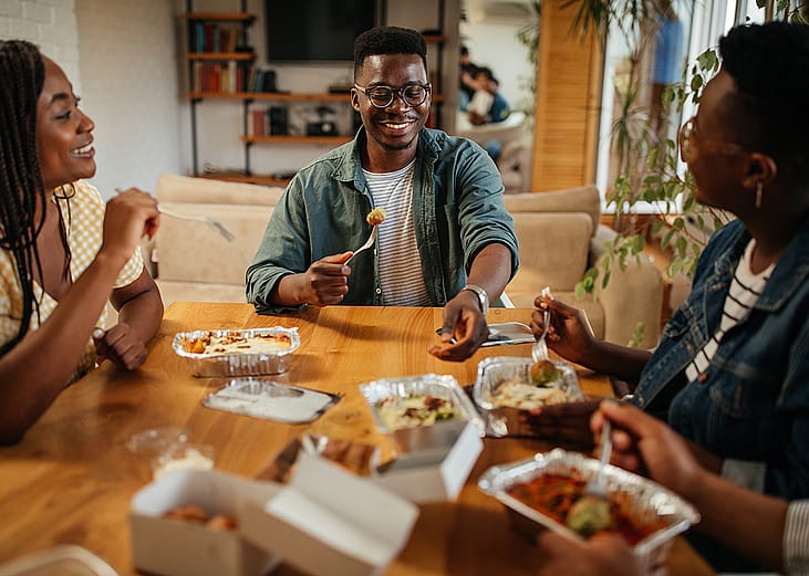 A group of friend enjoying takeaway at home.