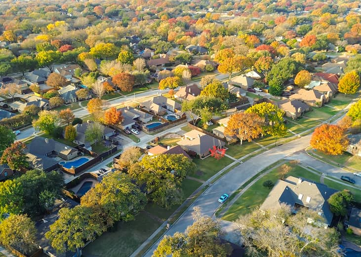 An aerial view of a suburban residential neighborhood during autumn season.