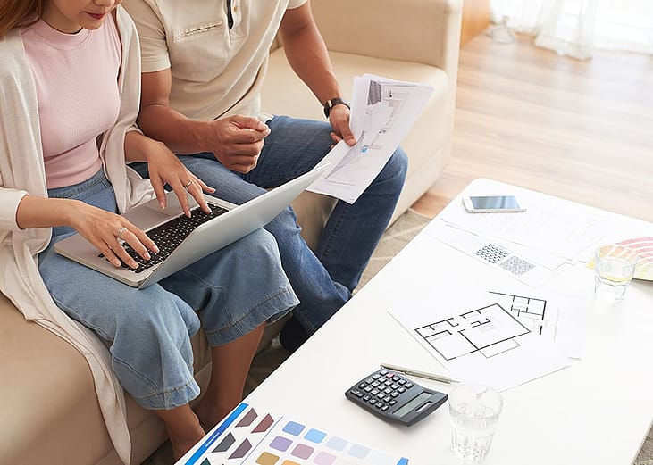 A newly married couple discussing their house renovation plans and budget at home.