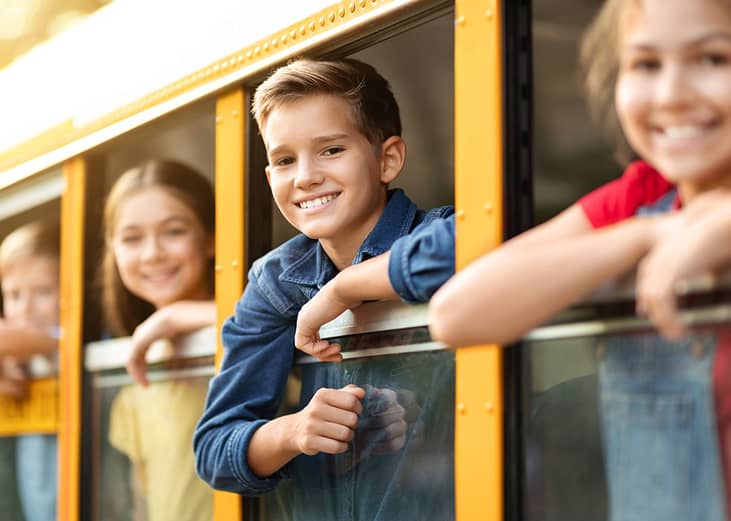 Excited school children peeping from the school bus window before a field trip.