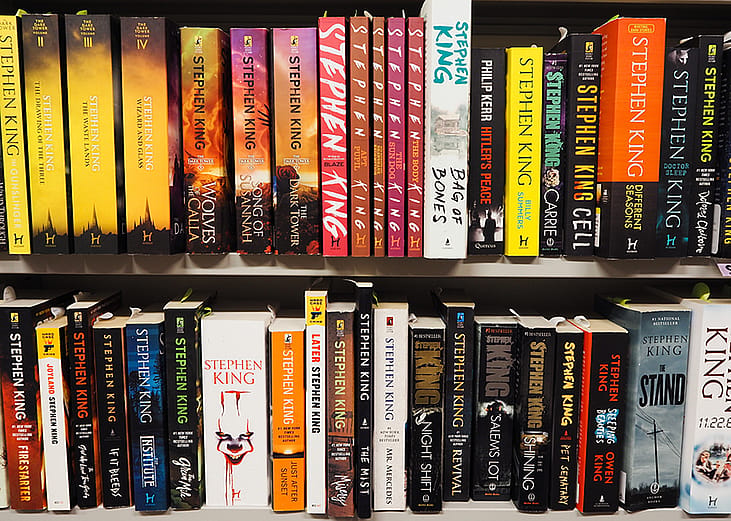 Stephen King's novels arranged in a shelf from a bookstore.  