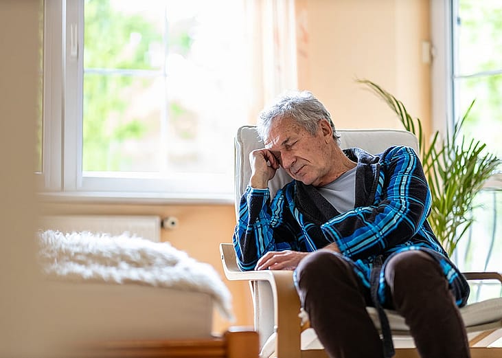 A senior man at home feeling depressed.