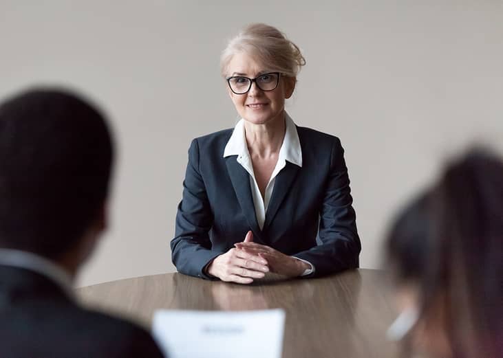 A senior HR recruiter interviewing candidates for a role.