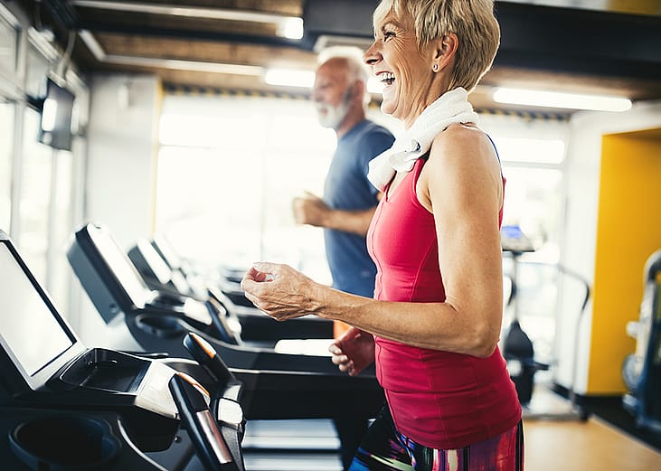 Senior people using treadmill at a gym