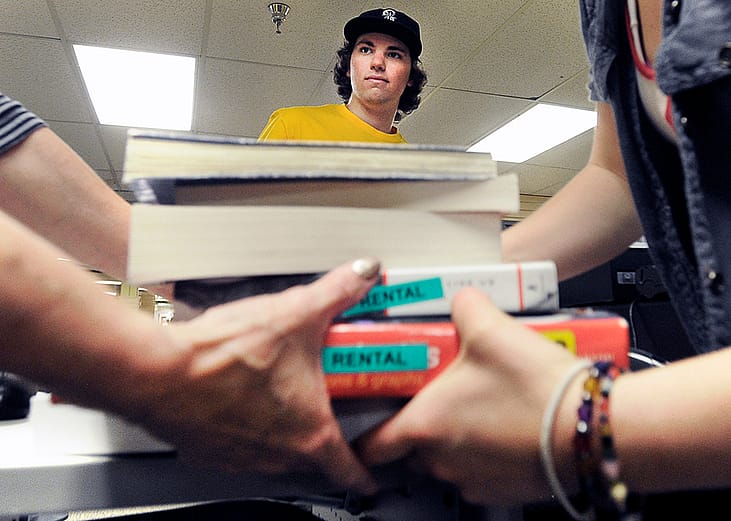Evan Michalec, a sophomore from the University of Colorado, standing between people who carried his textbooks after selling them back to the CU bookstore.
