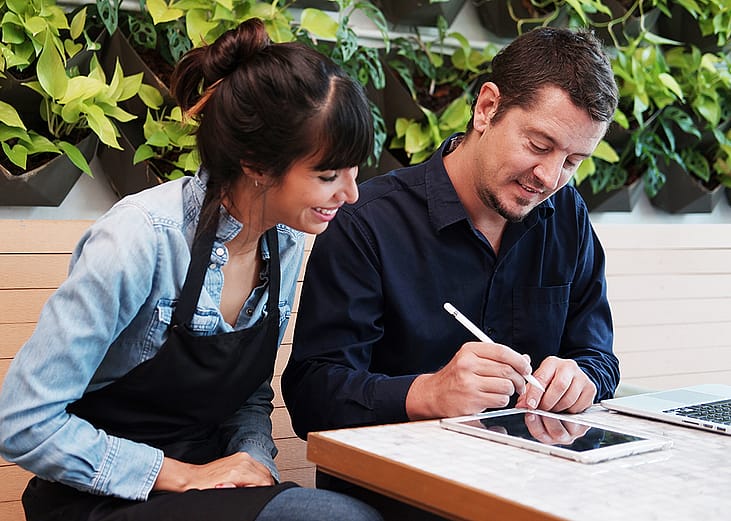 A couple who are small business owners discussing reports together in their store.