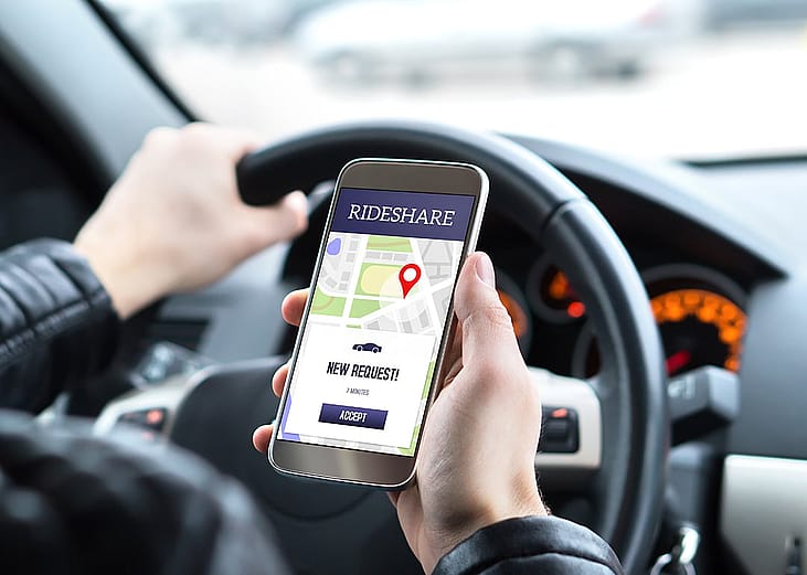 A rideshare car driver checking a new ride request.