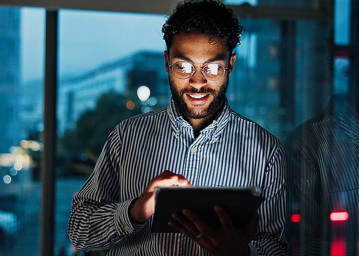 A finance consultant analyzing stock market data from his work tablet in the office.