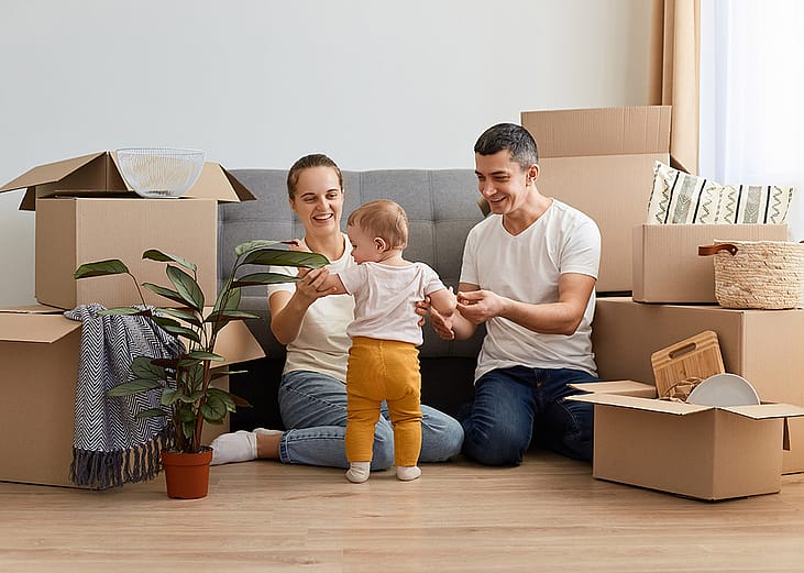 A young family unpacking moving boxes in their new home.