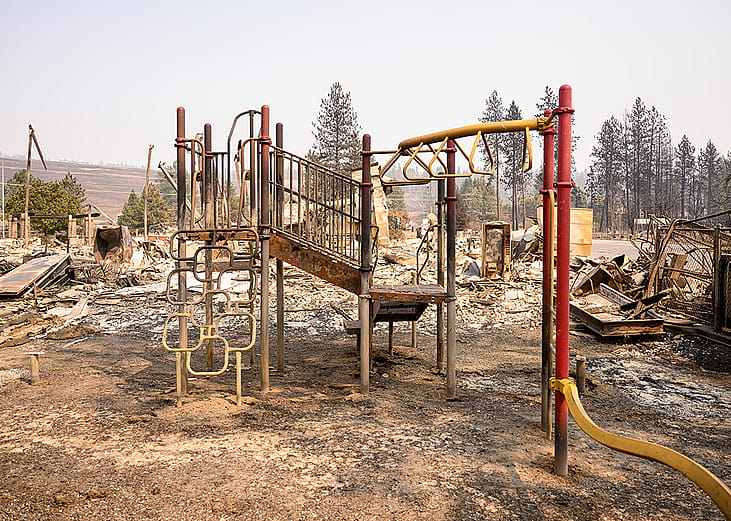 The burned remains of a playground are seen amidst the smoldering ashes of Riverside Real Life Church during the Old Trails fire in Spokane, Washington on August 4, 2026. 