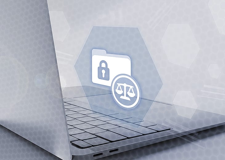 A laptop showing a holograph of secured folder and justice symbol icons, depicting a concept of legal compliance and data protection.
