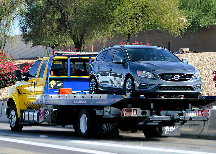 A roadside assistance truck picks up a car to service.