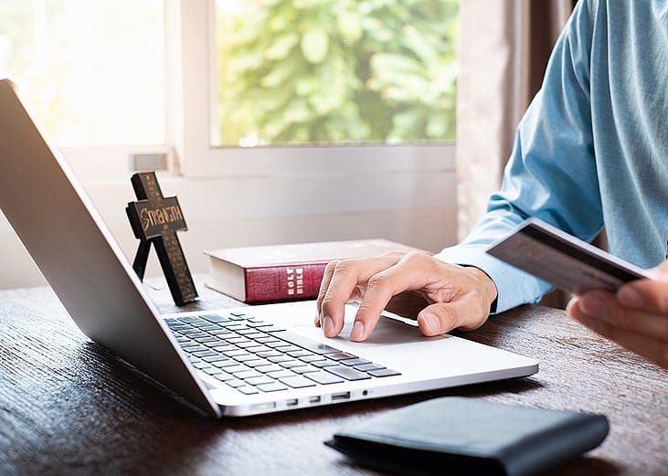 A church finance person using a credit card for an online transaction.