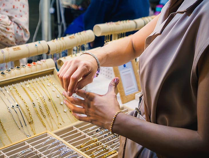 Close up of a woman trying on jewelry at a store.