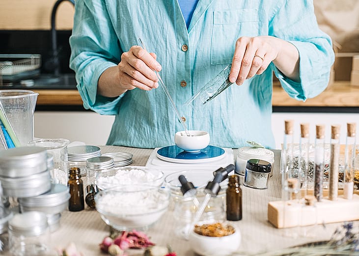 Person creating skincare mixtures at home using organic ingredients.