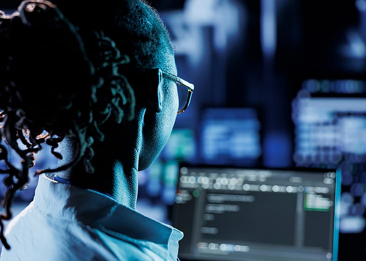 A trained cyber professional running code or program in a computer.