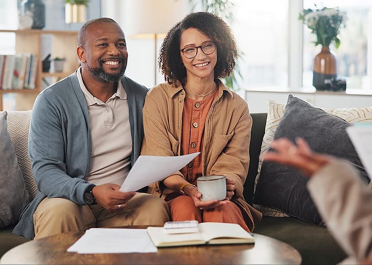 A middle-aged couple talking to a real estate professional during a consultation.