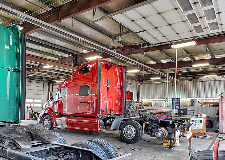 A repair shop with grease pit and equipment for fixing semi-sized and large over-the-road trucks.
