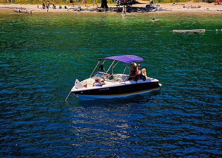 People relaxing on their Cobalt bowrider boat by the Emerald Bay in Lake Tahoe, California, USA.