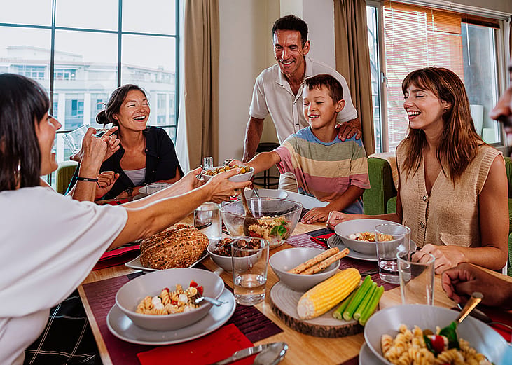 A diverse, multigenerational family sharing meals at the dinner table.