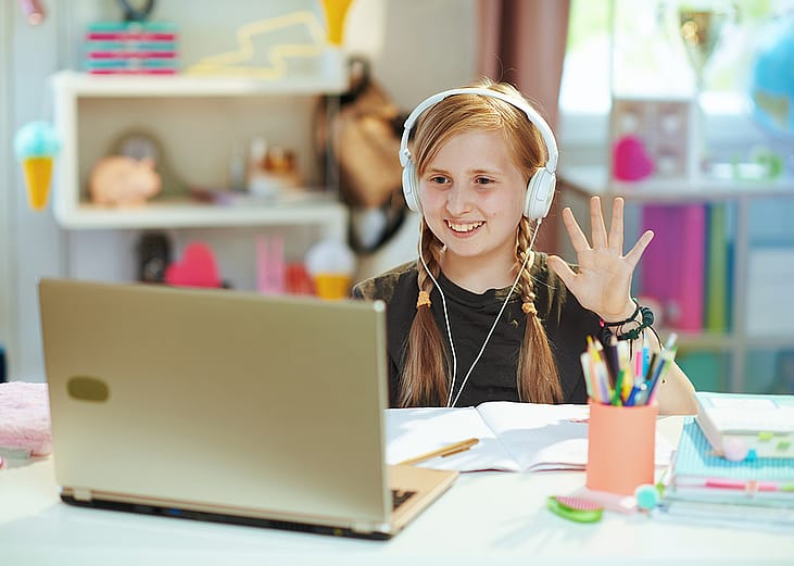 A young girl at home taking an online class.