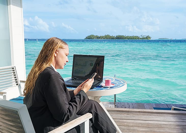 A young woman checking at dashboards and email while on a beach vacation.