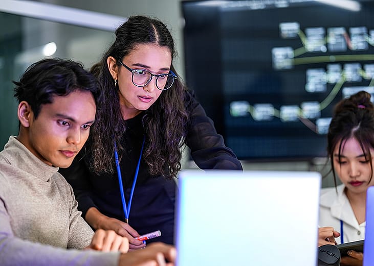 A focused group of developers working on a coding project.