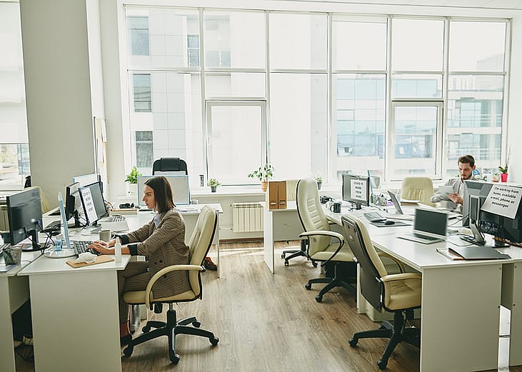 Employees sitting in a half-empty office.