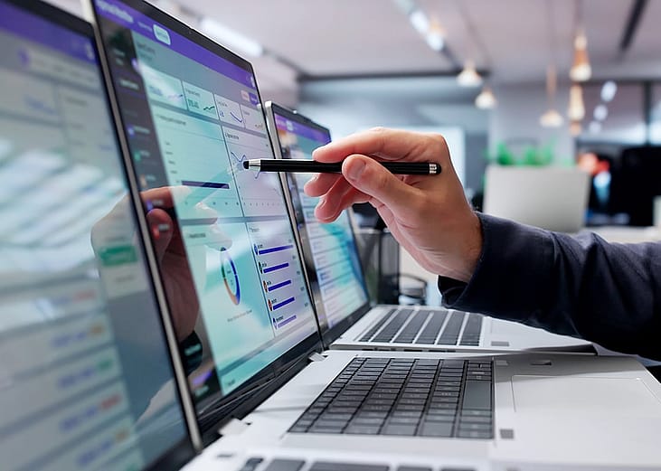 Businessman reviewing digital approval workflow tool on a laptop.