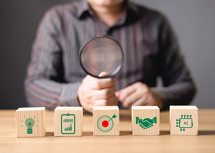 A business professional assessing enterprise strategy and AI investment tools with a magnifying glass.