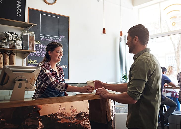 Barista giving a customer's cup of coffee