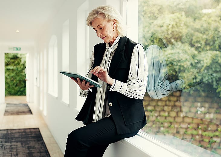 A realtor reviewing property information and viewing schedule from a digital tablet on-site.