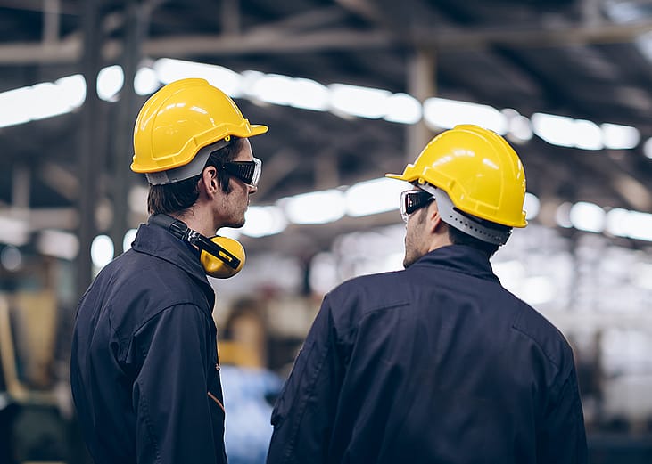 Maintenance engineers assessing operations and routine inspections in a factory.