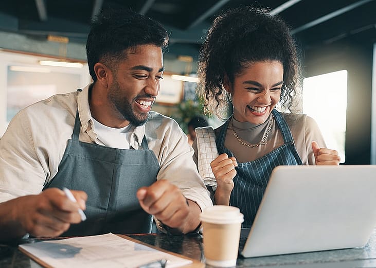 A team of small business owners happily reviewing business performance.