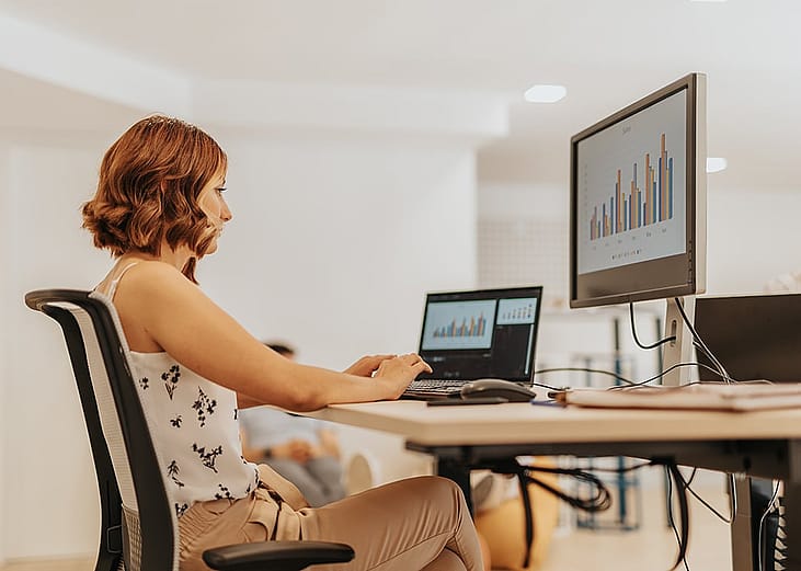 A data analyst reviewing data graphs and tools for a business sales dashboard.