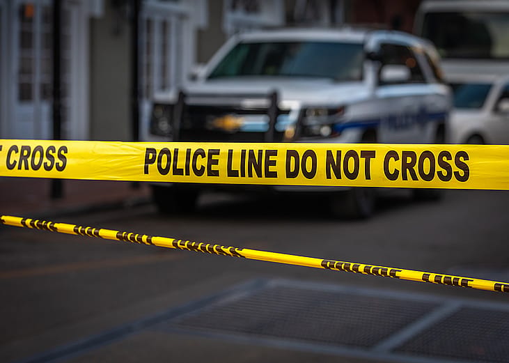 A 'Police Line Do Not Cross' tape at an entrance of a crime scene.