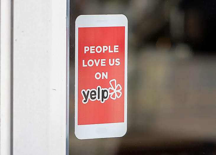 A 'People love us on Yelp' sticker at the entrance of a restaurant.