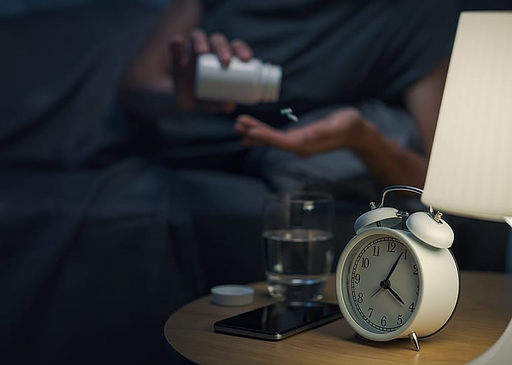 A woman taking medication at night.