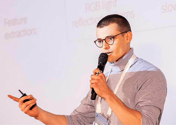 Filippo Nigro, the co-founder of You(th) giving a presentation holding a microphone.