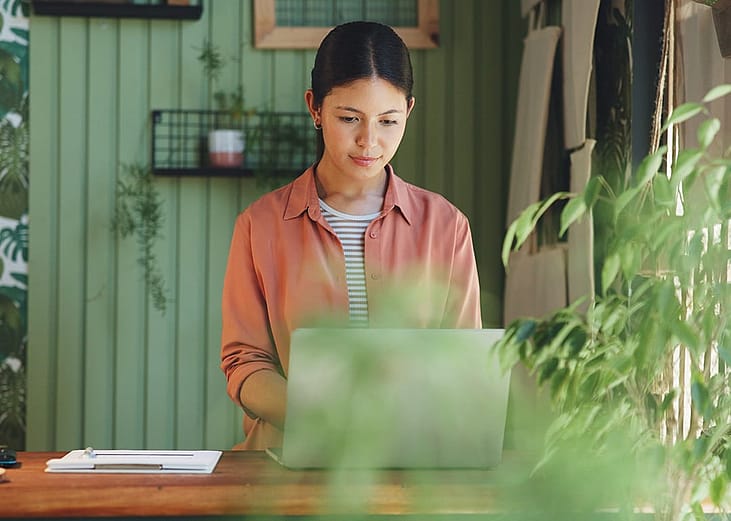 A young businesswoman checking laptop for orders.