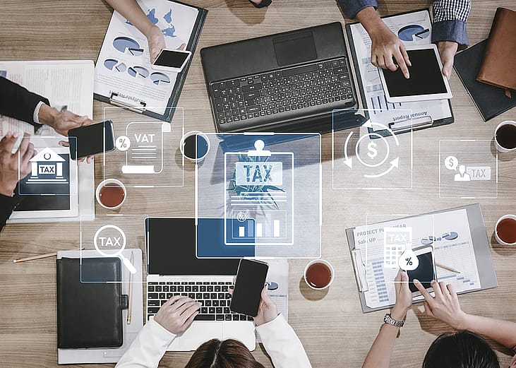 A conceptual graphic of a business team working around finance and tax compliance systems.