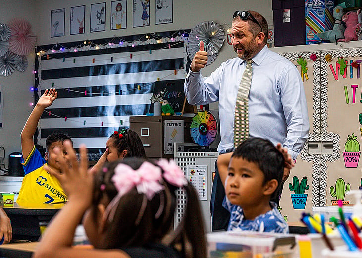 Principal Chris Ash greets students during the first day of class at Eisenhower Elementary School in Garden Grove, California.