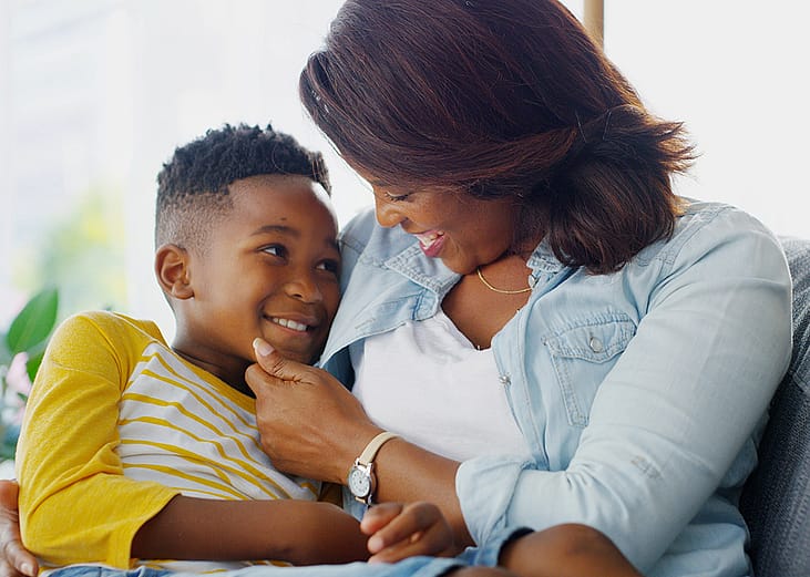 A parent and child bonding together at their home sofa.