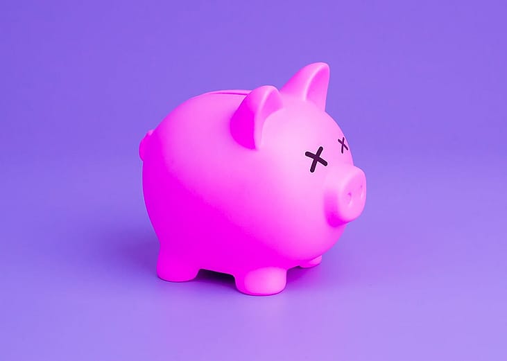 A pink piggy bank with crossed eyes as a concept of financial crisis.