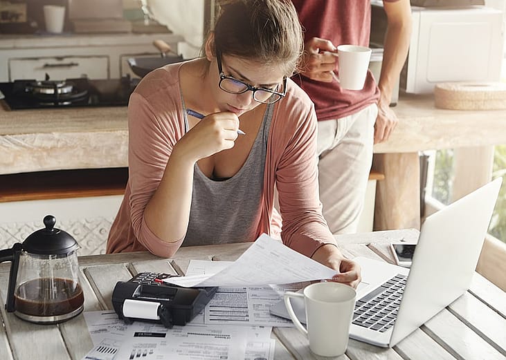 A spouse completing important documents for property taxes and other expenses at home.