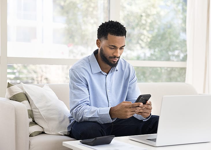 A busy man reviewing finances from his phone.