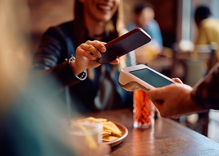 Customer paying for her food with contactless payment through phone.