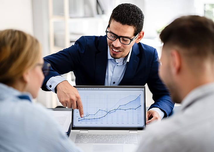 A financial planner explaining graphs to a young couple.