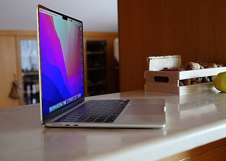 A side view of a Macbook Air M2 chip model on a table.